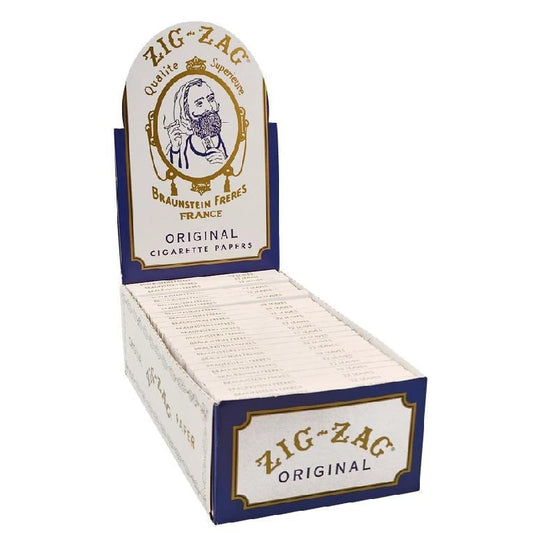 A 24-piece display of Zig Zag Original rolling papers with single wide size, featuring 32 leaves per booklet. The packaging is predominantly white and blue with a visible brand logo and the phrase 'Original Cigarette Papers'.